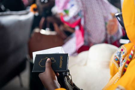 Beautiful black young woman traveling alone near windowの写真素材