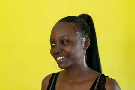 Beautiful dark skin young woman portrait on yellowの写真素材