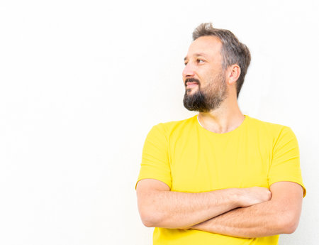 One positive man with yellow shirt portrait against wallの写真素材