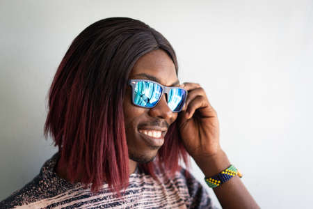 Funny black boy with long hair and sunglasses laughingの写真素材