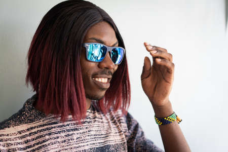 Funny black boy with long hair and sunglasses laughingの写真素材