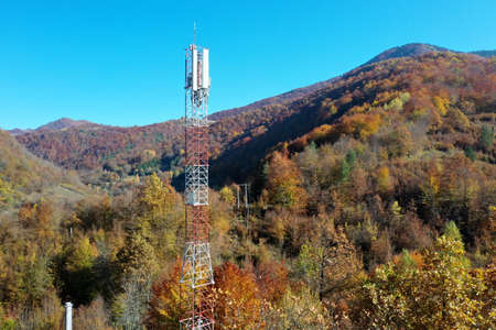 Telecommunications antenna tower in the morning. bright sunshine and blue sky with clouds. Transmitting antenna pairs. High quality photoの写真素材