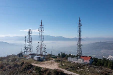 Telecommunications antenna tower in the morning. bright sunshine and blue sky with clouds. Transmitting antenna pairs. High quality photoの写真素材