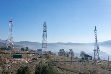 Telecommunications antenna tower in the morning. bright sunshine and blue sky with clouds. Transmitting antenna pairs. High quality photoの写真素材