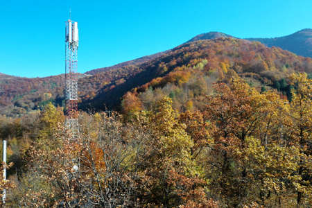 Telecommunications antenna tower in the morning. bright sunshine and blue sky with clouds. Transmitting antenna pairs. High quality photoの写真素材