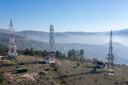 Telecommunications antenna tower in the morning. bright sunshine and blue sky with clouds. Transmitting antenna pairs. High quality photoの写真素材