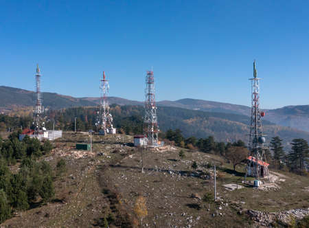 Telecommunications antenna tower in the morning. bright sunshine and blue sky with clouds. Transmitting antenna pairs. High quality photoの写真素材
