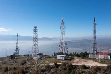 Telecommunications antenna tower in the morning. bright sunshine and blue sky with clouds. Transmitting antenna pairs. High quality photoの写真素材