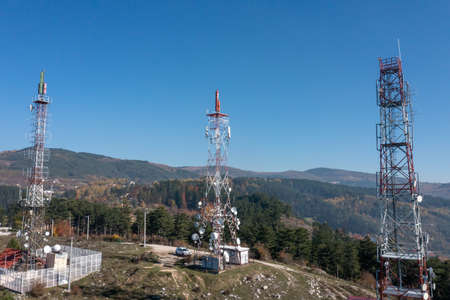 Telecommunications antenna tower in the morning. bright sunshine and blue sky with clouds. Transmitting antenna pairs. High quality photoの写真素材