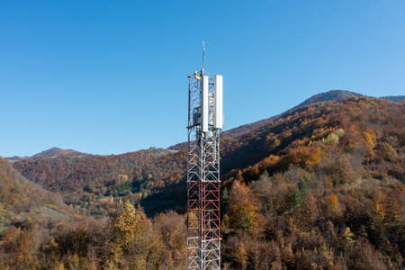 Telecommunications antenna tower in the morning. bright sunshine and blue sky with clouds. Transmitting antenna pairs. High quality photoの写真素材