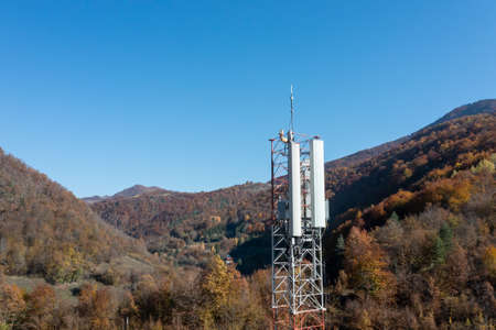 Telecommunications antenna tower in the morning. bright sunshine and blue sky with clouds. Transmitting antenna pairs. High quality photoの写真素材