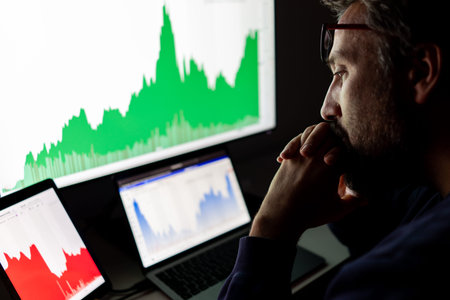 Crypto trader investor analyst looking at screen analyzing financial graph data on pc monitor,...