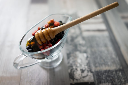 Honey with fresh raw berries forest strawberry. High quality photoの写真素材