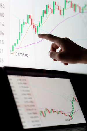 Crypto trader investor analyst looking at computer screen analyzing financial graph data on pc monitor, thinking of online stock exchange market .の写真素材