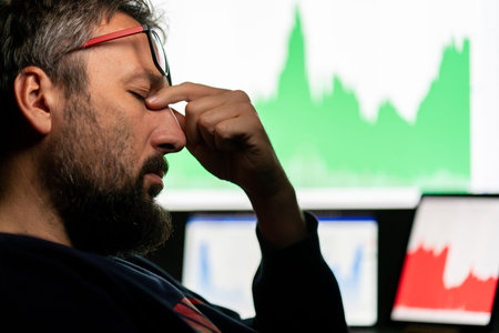 Depressed businessman in front of computer with graph of unsuccessful business on the screen. High...