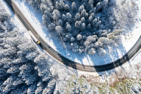 Car on road in winter trough a forest covered with snow. High quality photoの写真素材