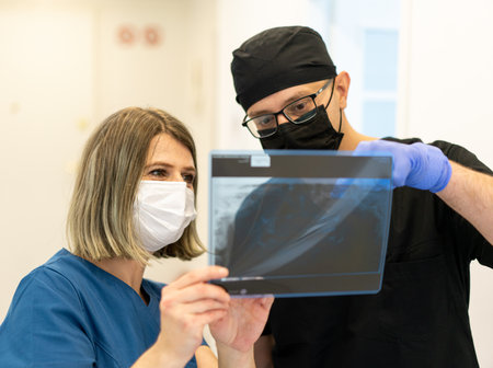 Two doctors checking x-ray image in hospital, quality photoの写真素材