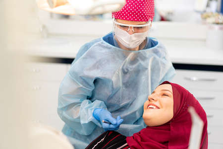Muslim Middle Eastern girl inside dentist office. high quality photoの写真素材