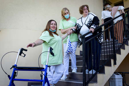 Senior disabled person in wheelchair needs nurse assistanceの写真素材