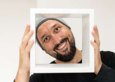 Happy adult man with frame. High quality photoの写真素材