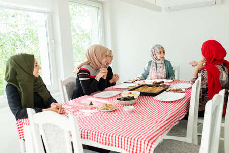Muslim family and friends gathering together at home for eating dinner. High quality photoの写真素材