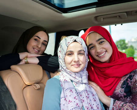 Muslim female friends enjoying road trip traveling at vacation in the car. High quality photoの写真素材
