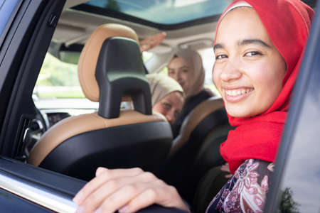 Muslim female friends enjoying road trip traveling at vacation in the car. High quality photoの写真素材