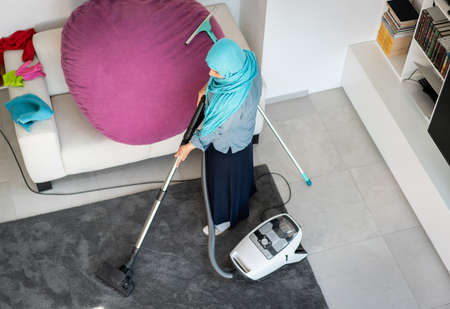 Happy Muslim Woman Cleaning Modern House Living Room. High quality photoの写真素材