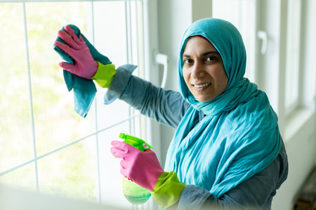 Happy Muslim Woman Cleaning Modern House Living Room. High quality photoの写真素材