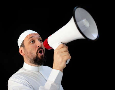 Muslim pilgrim in white traditional clothes, saying message on megaphone. High quality photoの写真素材