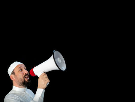 Muslim pilgrim in white traditional clothes, saying message on megaphone. High quality photoの写真素材