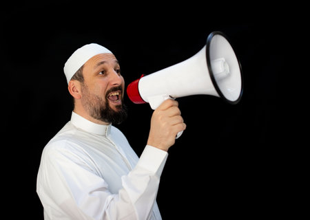 Handsome man with beard shouting through megaphone for Hajj in Mekkahの写真素材