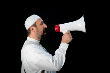 Handsome man with beard shouting through megaphone for Hajj in Mekkahの写真素材
