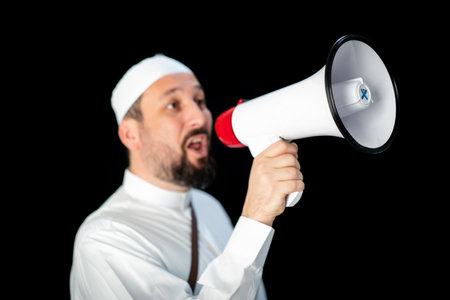 Handsome man with beard shouting through megaphone for Hajj in Mekkahの写真素材
