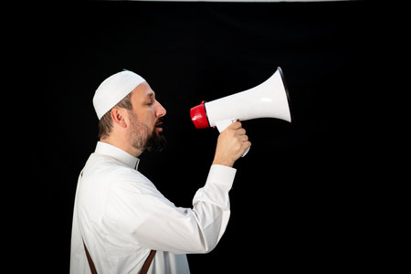 Handsome man with beard shouting through megaphone for Hajj in Mekkahの写真素材