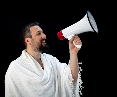 Handsome man with beard shouting through megaphone for Hajj in Mekkahの写真素材
