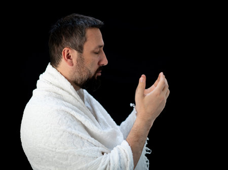 Muslim man standing and praying in the front of Kaaba in Mecca, KSAの写真素材