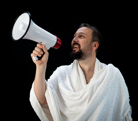Handsome man with beard shouting through megaphone for Hajj in Mekkahの写真素材