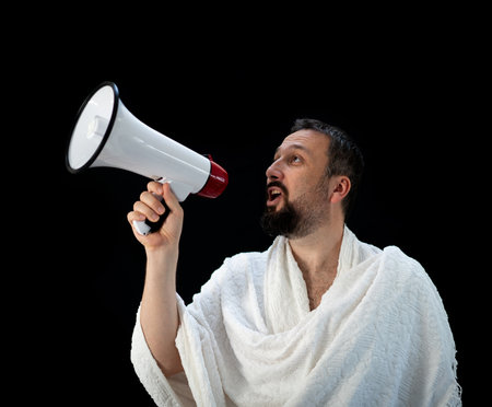 Handsome man with beard shouting through megaphone for Hajj in Mekkahの写真素材