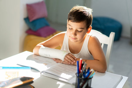 Back to school. Thinking child boy writing, drawing in notebook sitting at desk and doing homework....