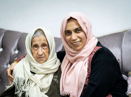 Portrait of woman hugging daughter with positive face. Third age, Home care concept. High quality photoの写真素材