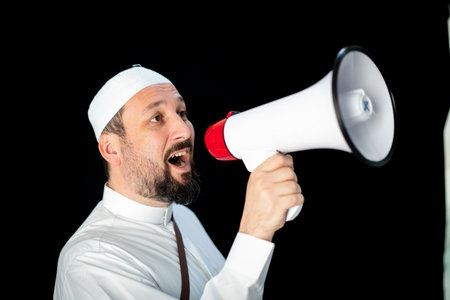 Handsome man with beard shouting through megaphone for Hajj in Mekkahの写真素材