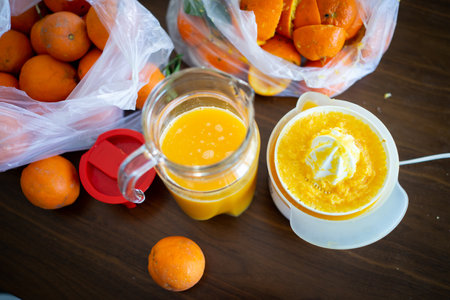 Summer fresh orange fruit getting squeezed in kitchenの写真素材