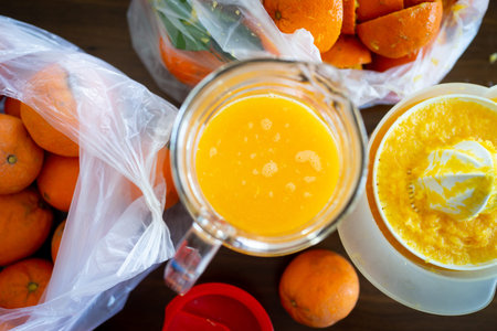 Summer fresh orange fruit getting squeezed in kitchen