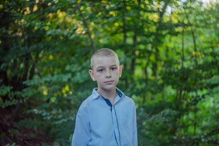 Cute little curious boy in green nature waiting for magic. Inquisitive childhood.