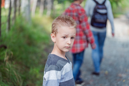 Cute little curious boy in green nature waiting for magic. Inquisitive childhood.