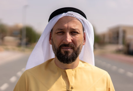 Tourist wearing traditional arab clothing walking outdoors on the streets on a sunny day. High...