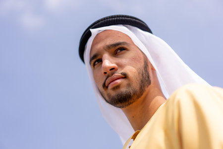 Low angle view of arab man outdoors wearing traditional arabic clothing.の写真素材