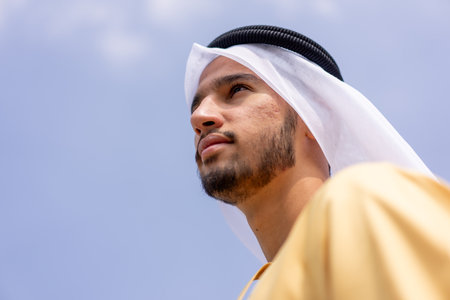 Low angle view of arab man outdoors wearing traditional arabic clothing.の写真素材