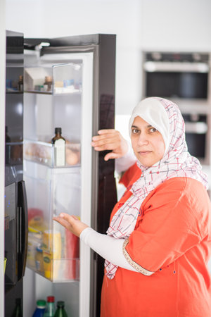 Muslim woman in kitchen preparing food for lunchの写真素材